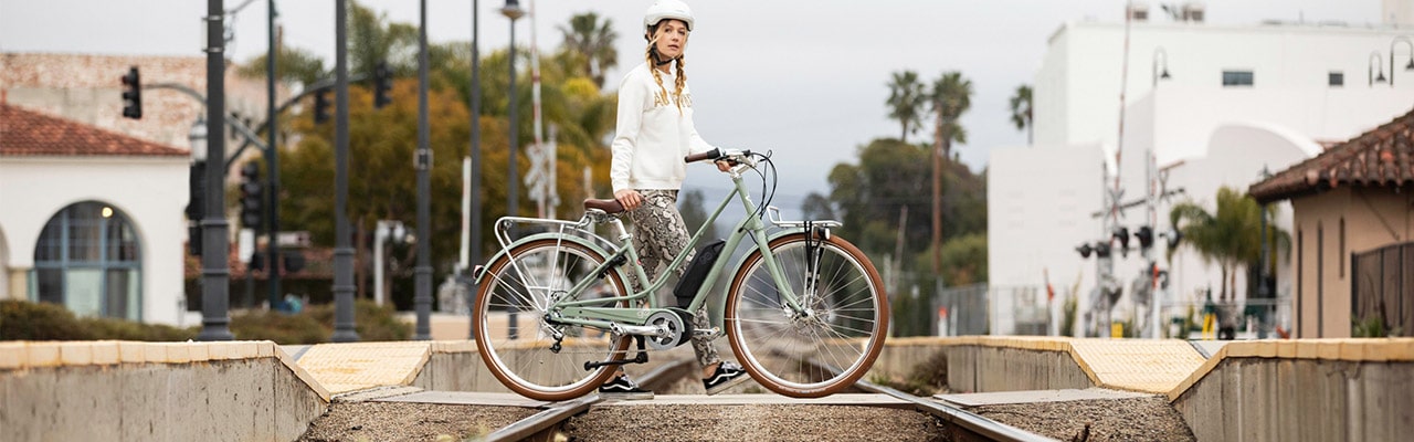 Frau mit Gazelle e-Bike am Bahnhof