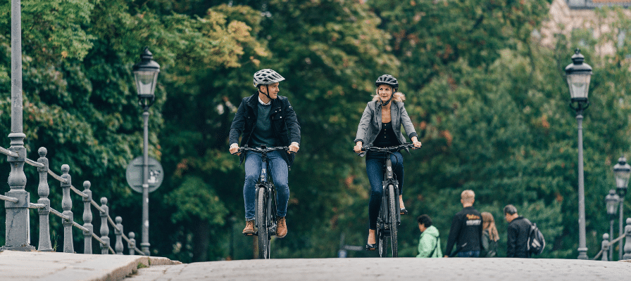 Zwei Menschen fahren auf e-Bikes über eine Brücke